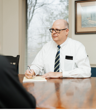 Business_Meeting_Man_writing_at_table
