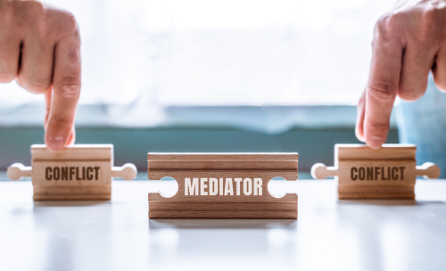 Hand,Holding,A,Wooden,Jigsaw,Puzzle,With,Conflict,And,Mediator